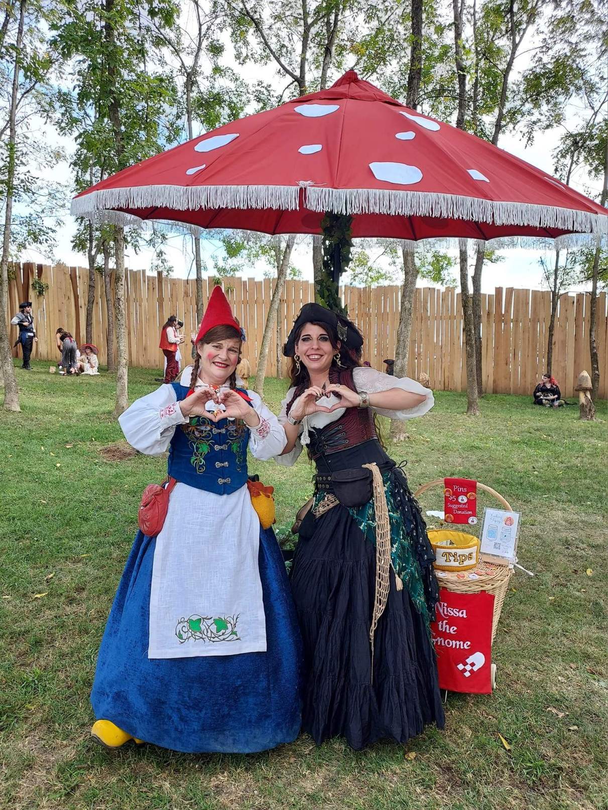 Nissa the Gnome taking a picture with a woman under a mushroom umbrella