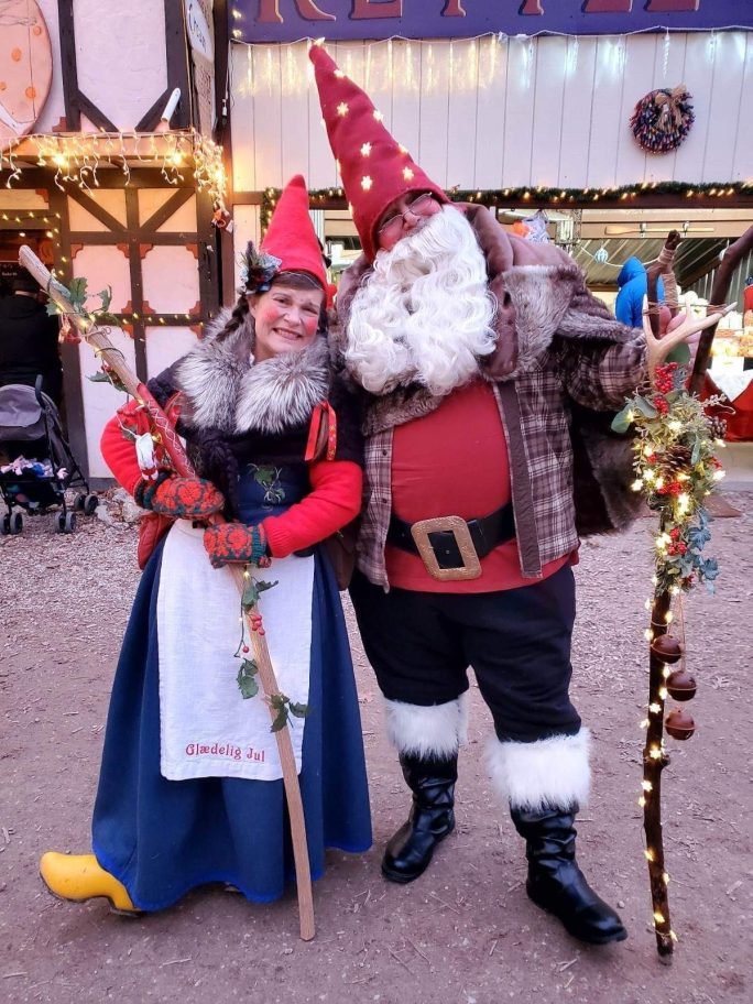 Nissa the Christmas Gnome posing for a photo op with a patron dressed as a gnome